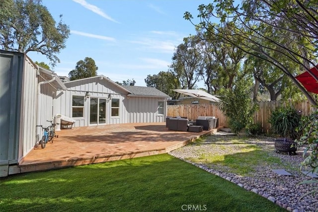 view of yard featuring a deck, outdoor lounge area, and fence