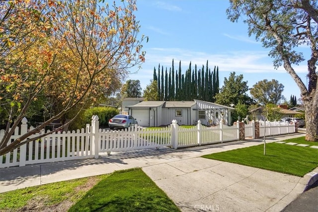 view of front of house featuring a fenced front yard, a front lawn, concrete driveway, and an attached garage