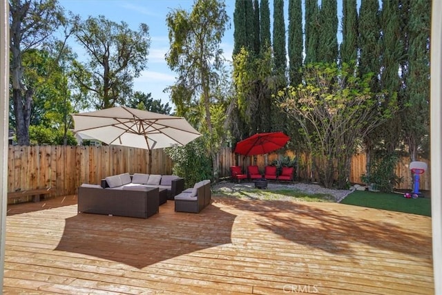 wooden deck featuring an outdoor living space and a fenced backyard