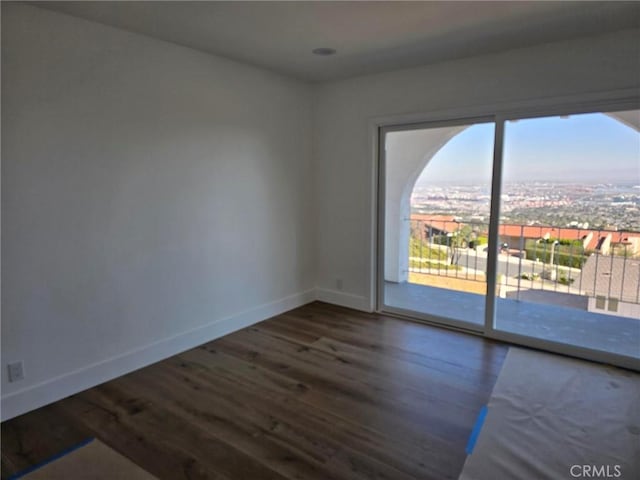 unfurnished room with wood finished floors and baseboards