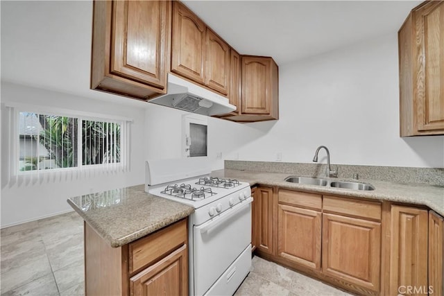 kitchen with brown cabinetry, white gas stove, a sink, light countertops, and under cabinet range hood