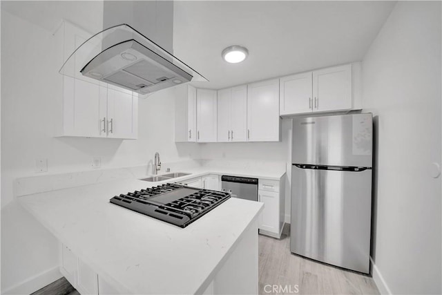 kitchen featuring extractor fan, appliances with stainless steel finishes, a peninsula, white cabinetry, and a sink