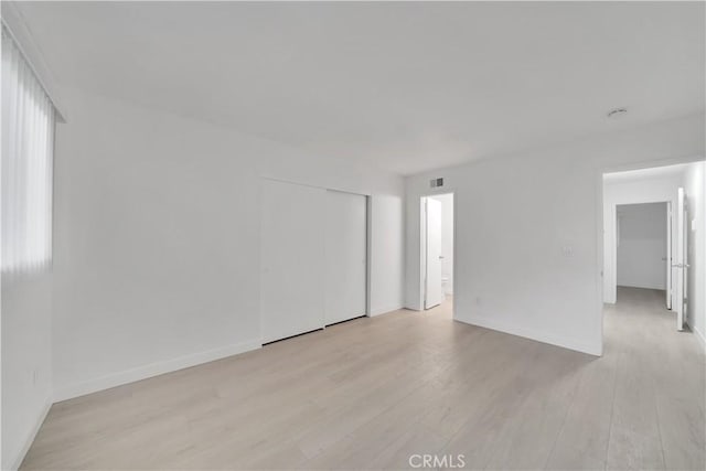 unfurnished room with visible vents, baseboards, and light wood-style flooring