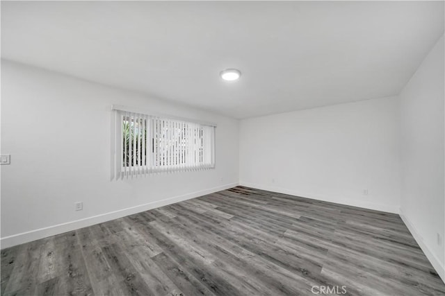 empty room with baseboards and wood finished floors