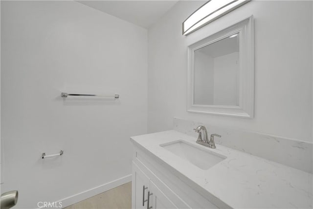 bathroom with vanity, baseboards, and wood finished floors