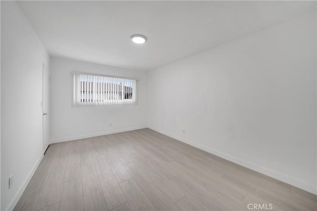 unfurnished room with wood finished floors and baseboards