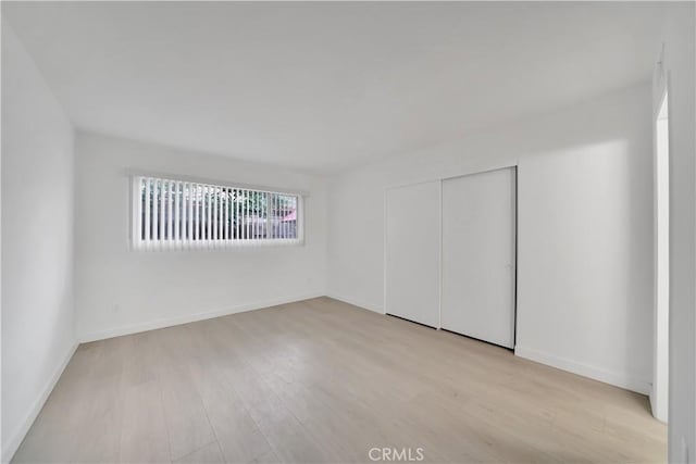 empty room featuring baseboards and wood finished floors