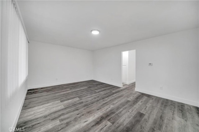 empty room with baseboards and wood finished floors