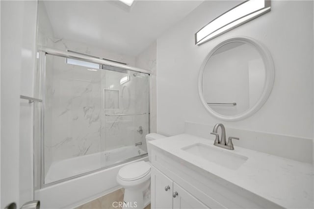 bathroom featuring toilet, vanity, and shower / bath combination with glass door