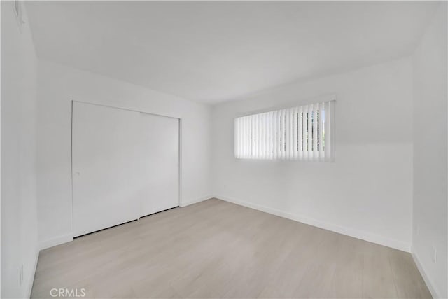 unfurnished room featuring baseboards and wood finished floors