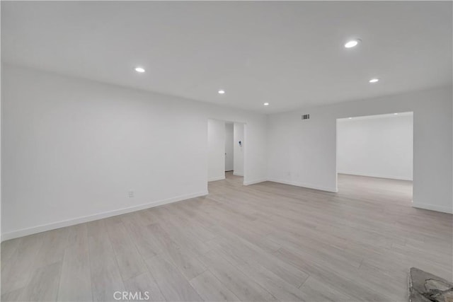 spare room with recessed lighting, light wood-type flooring, baseboards, and visible vents