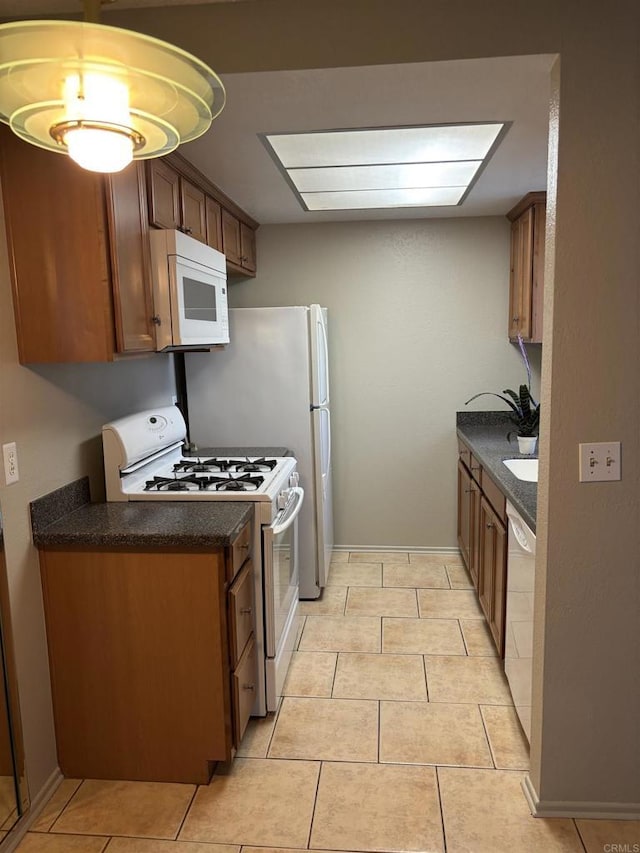 1169EAST Cornell Ave Unit 52, Redlands, CA 92374 - kitchen featuring brown cabinetry, light tile patterned floors, dark countertops, and white appliances