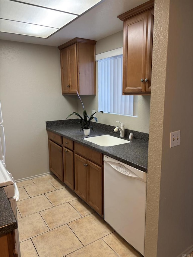 1169EAST Cornell Ave Unit 52, Redlands, CA 92374 - kitchen with light tile patterned flooring, a sink, white dishwasher, and dark countertops