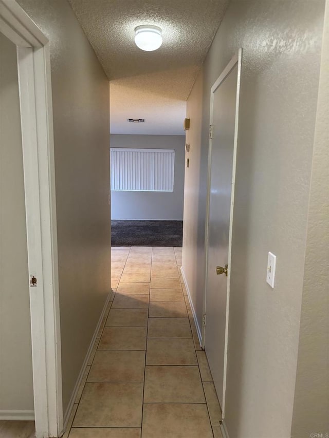 1169EAST Cornell Ave Unit 52, Redlands, CA 92374 - hallway featuring a textured ceiling, light tile patterned floors, baseboards, and visible vents