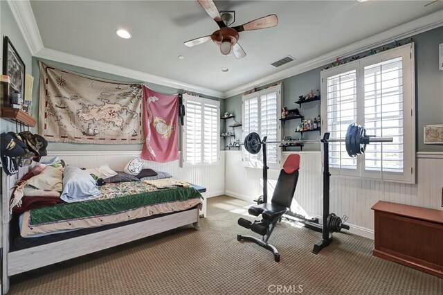 bedroom featuring visible vents, ornamental molding, and wainscoting