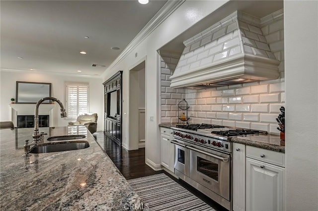 4 Andromeda Isle, Ladera Ranch, CA 92694 - kitchen featuring double oven range, custom exhaust hood, ornamental molding, dark stone countertops, and white cabinetry