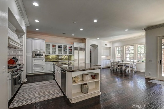 4 Andromeda Isle, Ladera Ranch, CA 92694 - kitchen featuring premium appliances, open shelves, crown molding, arched walkways, and white cabinets
