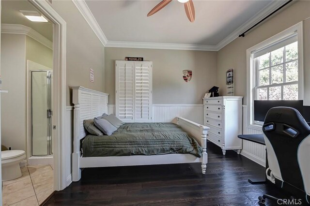 bedroom with wood finished floors, crown molding, ceiling fan, and ensuite bathroom