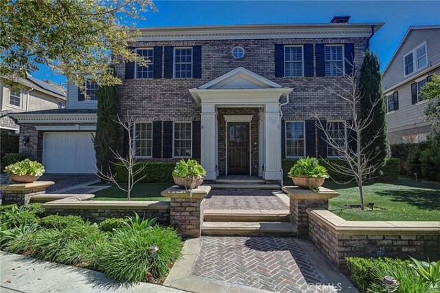 colonial-style house featuring brick siding and an attached garage