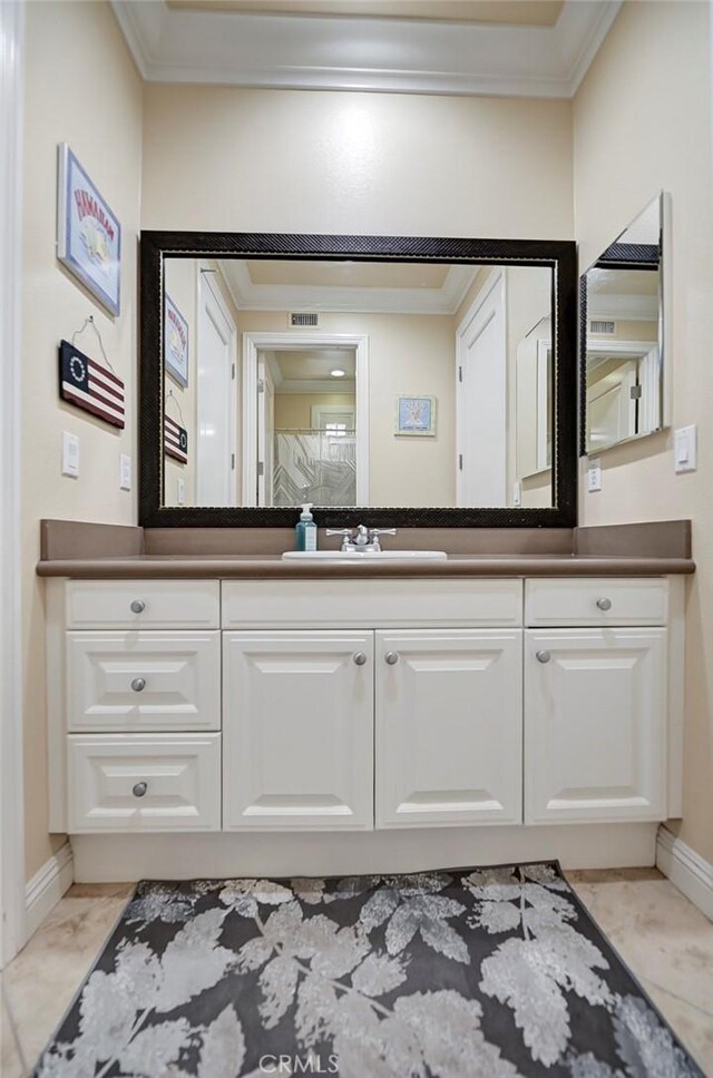 bathroom with vanity, marble finish floor, baseboards, ornamental molding, and visible vents
