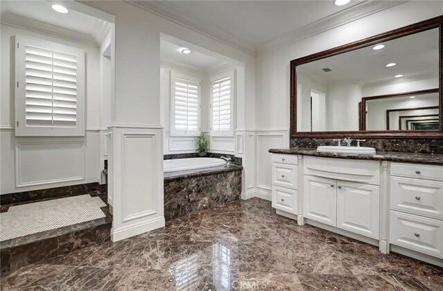 bathroom featuring a wainscoted wall, marble finish floor, crown molding, vanity, and a decorative wall