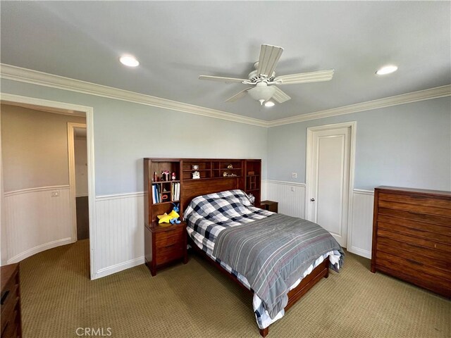 carpeted bedroom with a wainscoted wall, recessed lighting, and ornamental molding