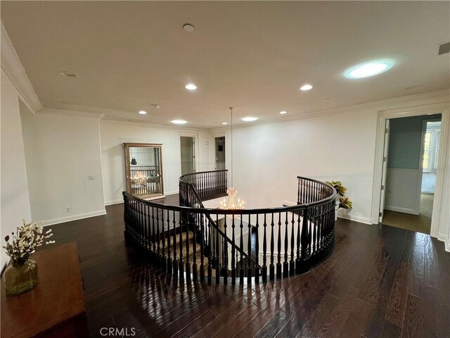 hall featuring hardwood / wood-style flooring, crown molding, and an upstairs landing