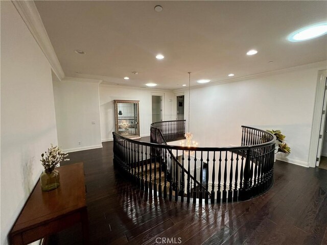 hallway featuring an upstairs landing, hardwood / wood-style flooring, baseboards, ornamental molding, and recessed lighting