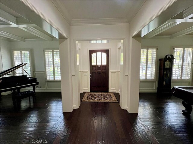 entryway with a healthy amount of sunlight, ornamental molding, and a decorative wall