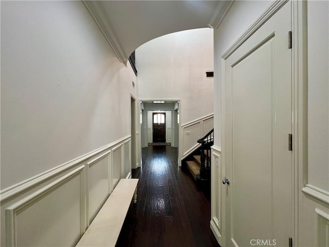4 Andromeda Isle, Ladera Ranch, CA 92694 - hallway with arched walkways, dark wood finished floors, wainscoting, ornamental molding, and stairs