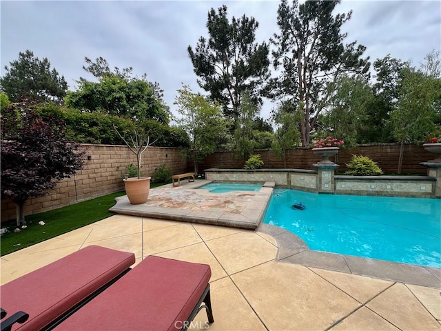 view of pool with a fenced in pool, a patio, a fenced backyard, and an in ground hot tub