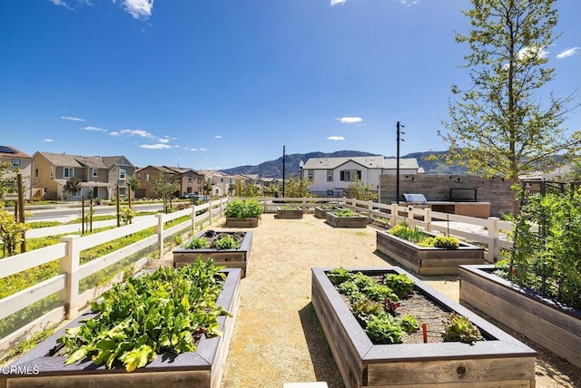 surrounding community featuring a residential view, a vegetable garden, and fence