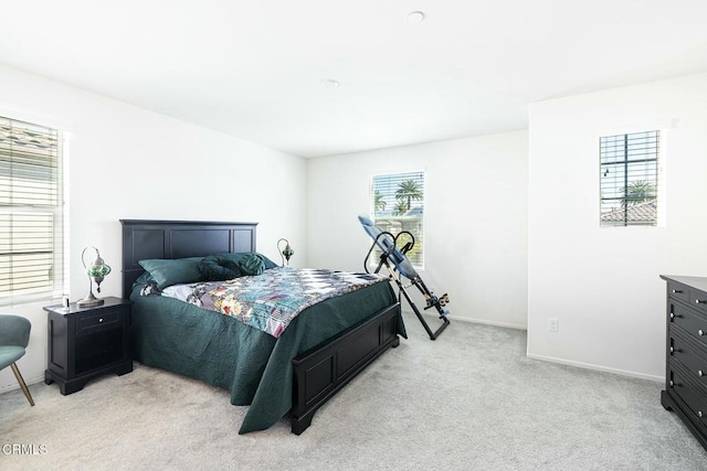 bedroom featuring light carpet and baseboards