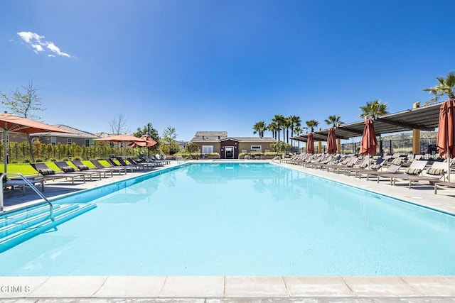 pool with a patio area and fence