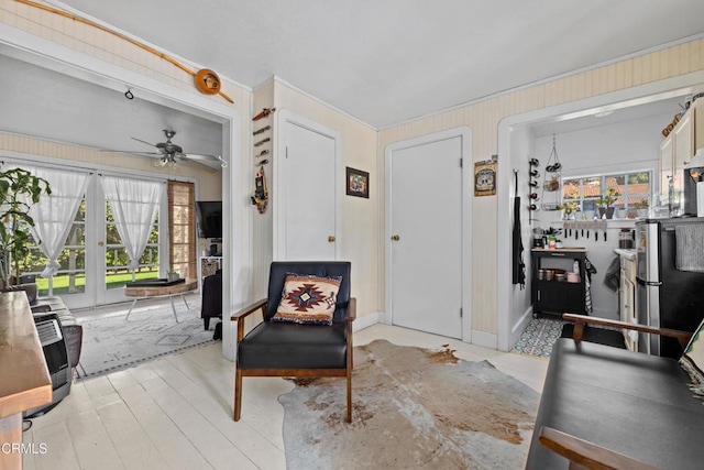 interior space featuring heating unit, wooden walls, ceiling fan, and light wood finished floors