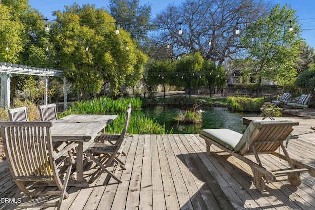 view of dock with a deck with water view and outdoor dining area