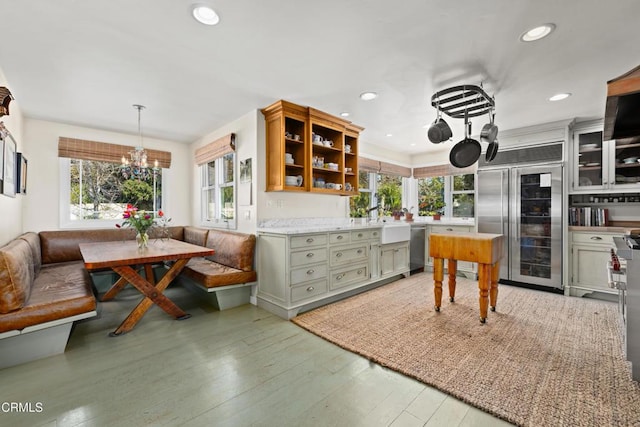 kitchen featuring light wood-type flooring, beverage cooler, plenty of natural light, breakfast area, and appliances with stainless steel finishes