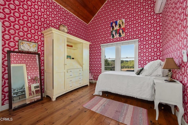 bedroom featuring wallpapered walls, a wall mounted AC, lofted ceiling, and hardwood / wood-style floors