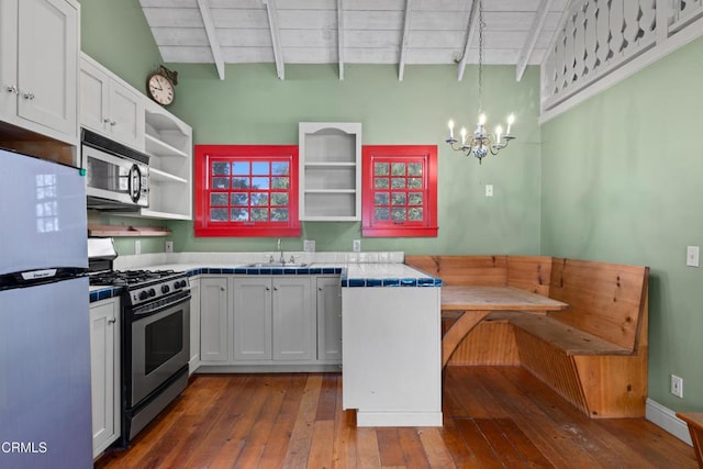 kitchen with beamed ceiling, open shelves, a sink, breakfast area, and stainless steel appliances