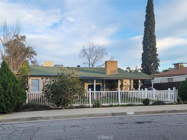 view of front of property featuring a fenced front yard and a chimney