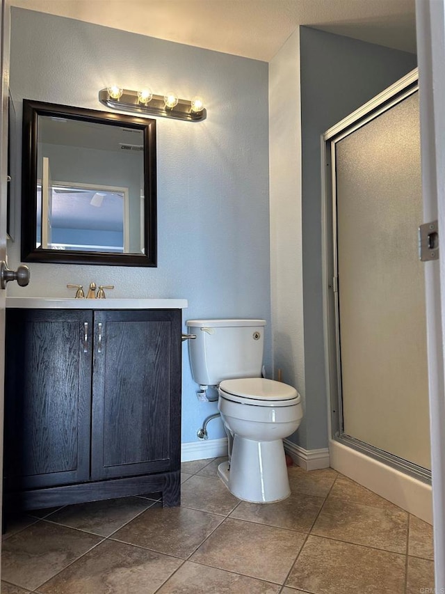 full bathroom with vanity, toilet, baseboards, and a stall shower