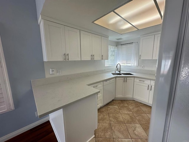 kitchen featuring white cabinets, white appliances, a peninsula, and a sink