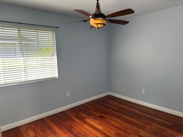 unfurnished room featuring a ceiling fan, dark wood-style flooring, and baseboards