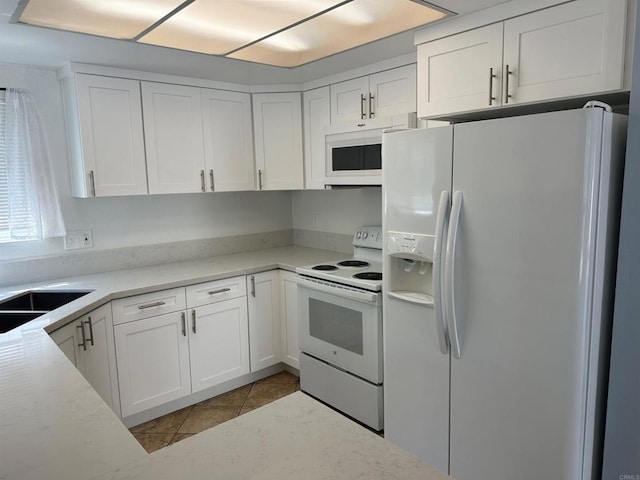 kitchen with white appliances, white cabinets, and light tile patterned floors