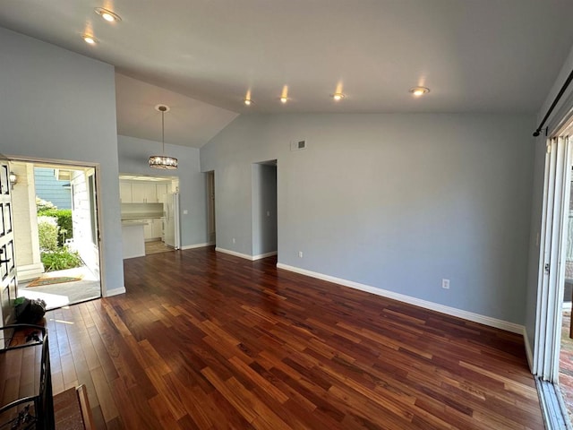 unfurnished living room with visible vents, baseboards, a chandelier, high vaulted ceiling, and dark wood-style flooring