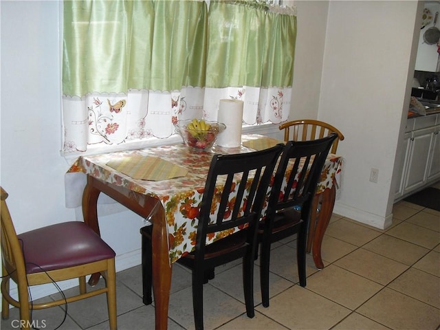 dining room with light tile patterned floors and baseboards