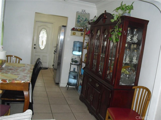 dining area with light tile patterned flooring and crown molding