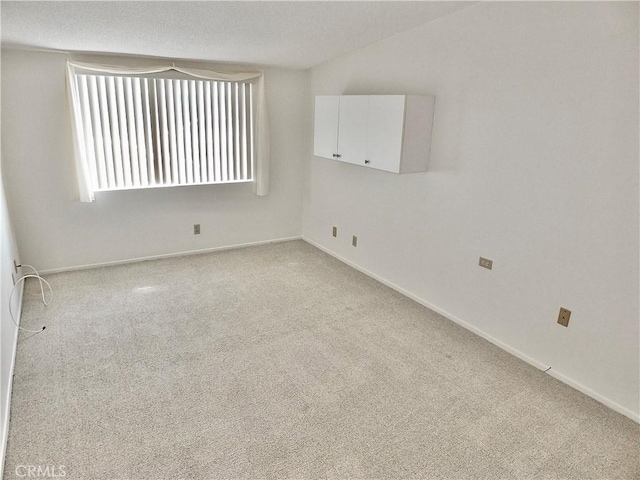 carpeted empty room with baseboards