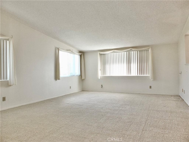 carpeted empty room with a textured ceiling