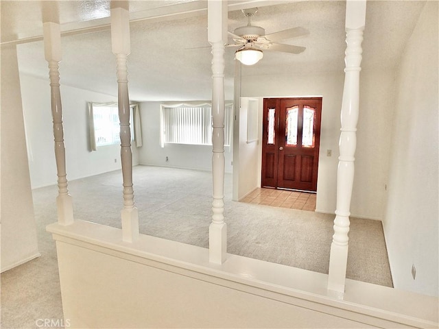 carpeted entryway with ceiling fan